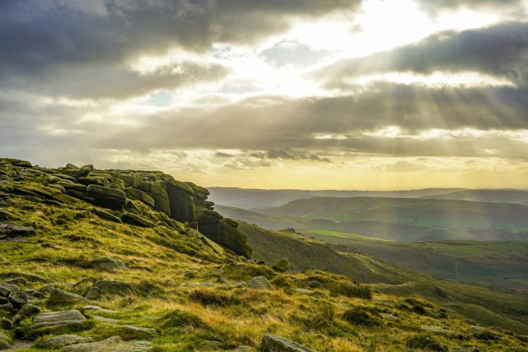 the sun shines through the clouds over the mountains